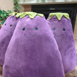 three purple plush eggplants with green stems against a stone wall.